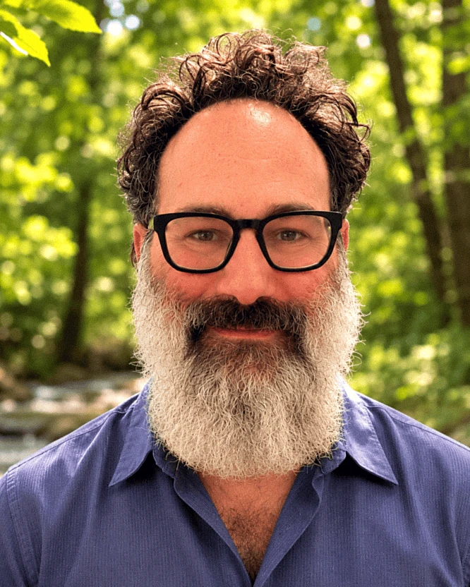 Moishe Goldstein, founder of Tikkun Ascend, photographed outdoors beside a creek.